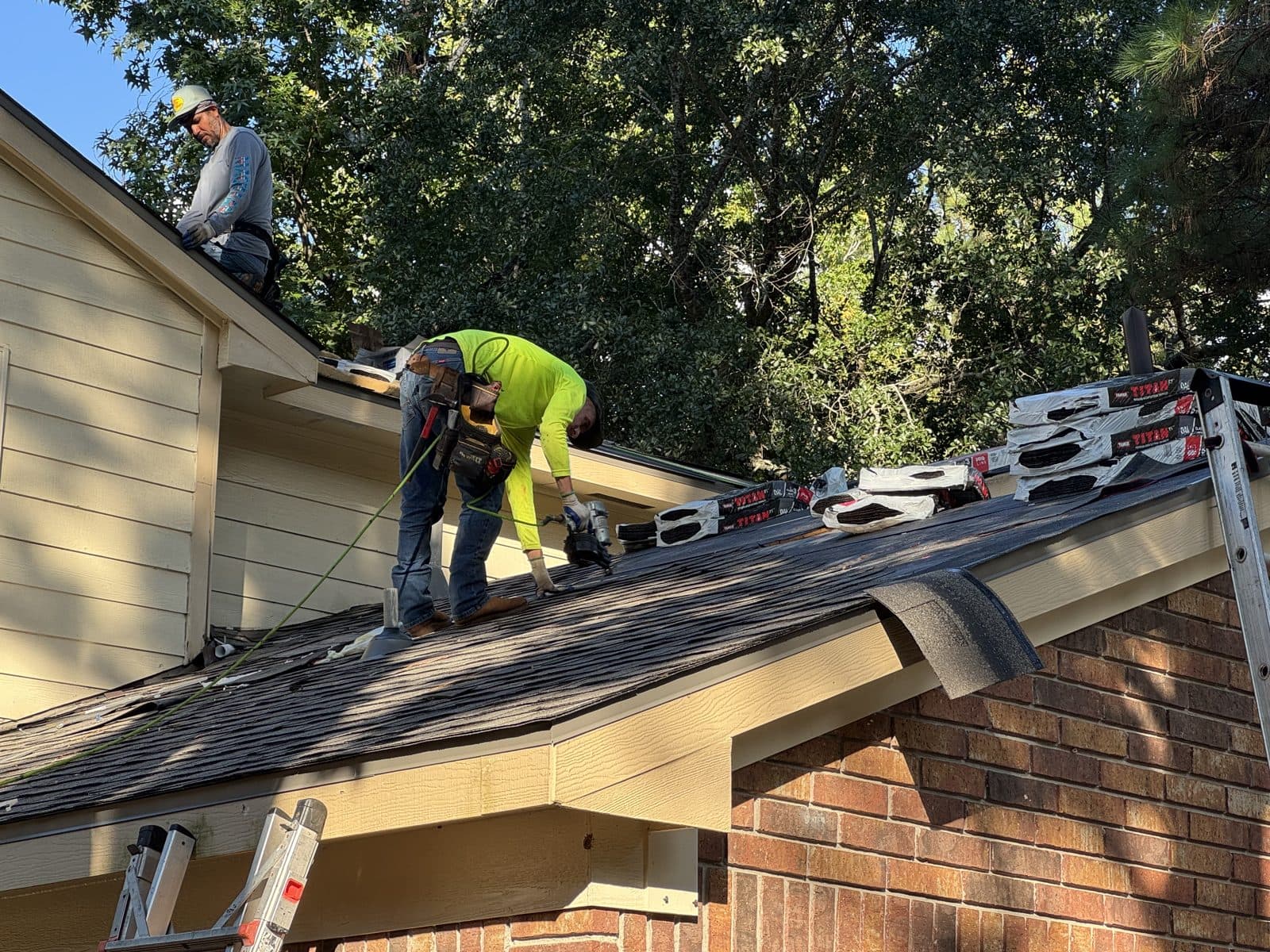 Crew repairing the edge of a shingle roof